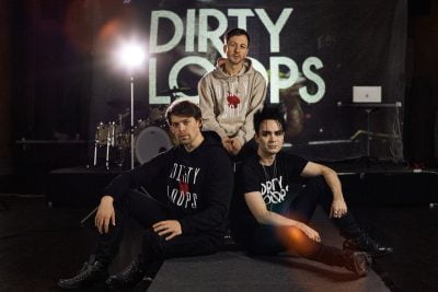 Bandet Dirty Loops poserar tillsammans framför en scen under en Clinic på Rytmus.