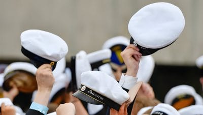 Studentmössor som viftas i luften.