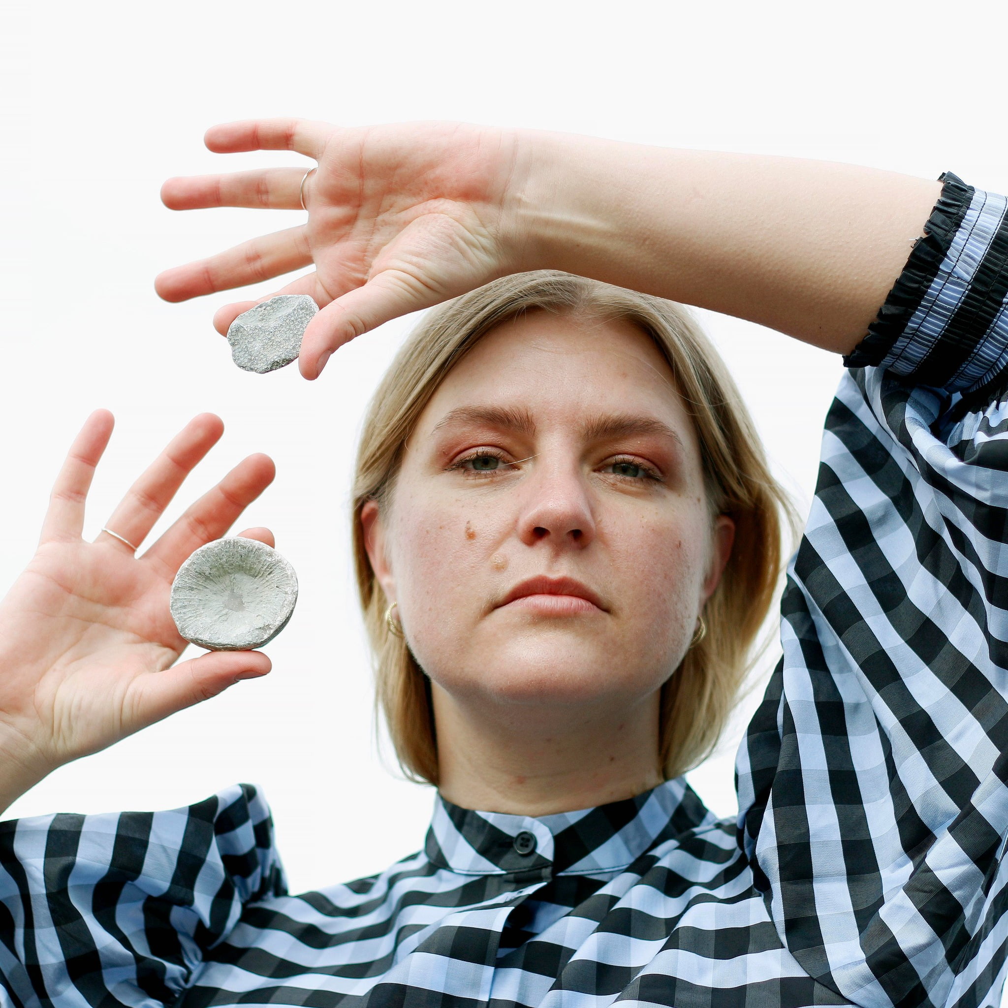 Sara Aldén håller upp två stenar och tittar in i kameran.