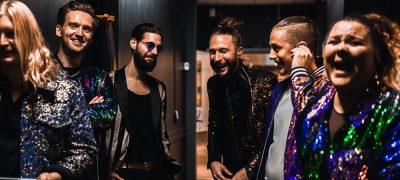 Bandet The mudd club skrattar tillsammans backstage.