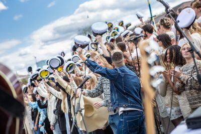 Studenter på lyfter upp studentmössor i ett soligt Göteborg.