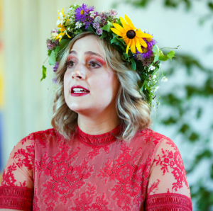 Före detta rytmuseleven Linnea tittar åt vänster med en blomsterkrans på huvudet.