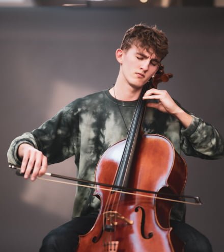 Elev blundar och spelar cello i en fotostudio.