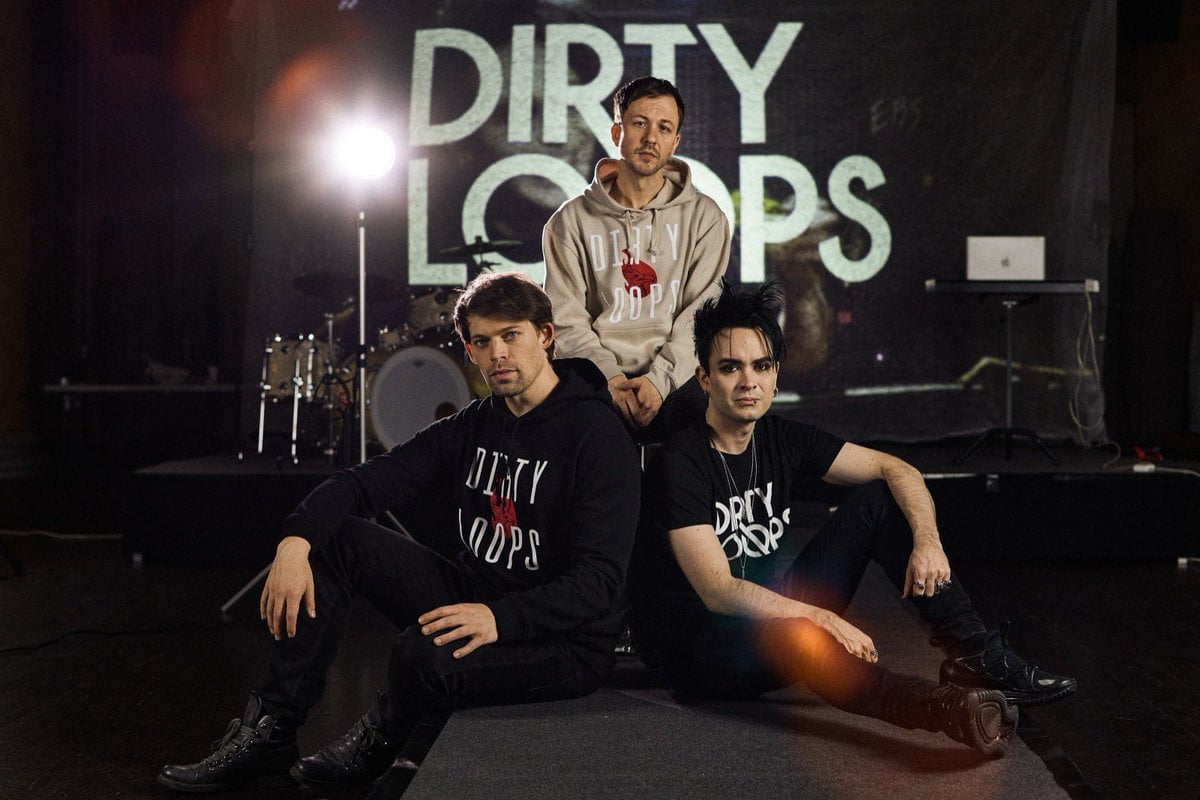 Bandet Dirty Loops poserar tillsammans framför en scen under en Clinic på Rytmus.