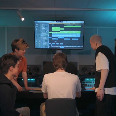 Fyra elever är samlade i en studio och klipper musik tillsammans.