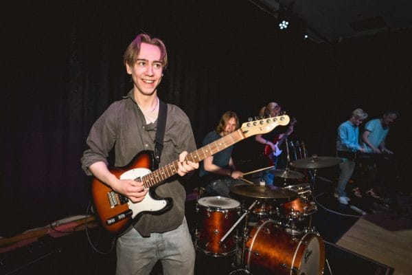 Kille spelar elgitarr.