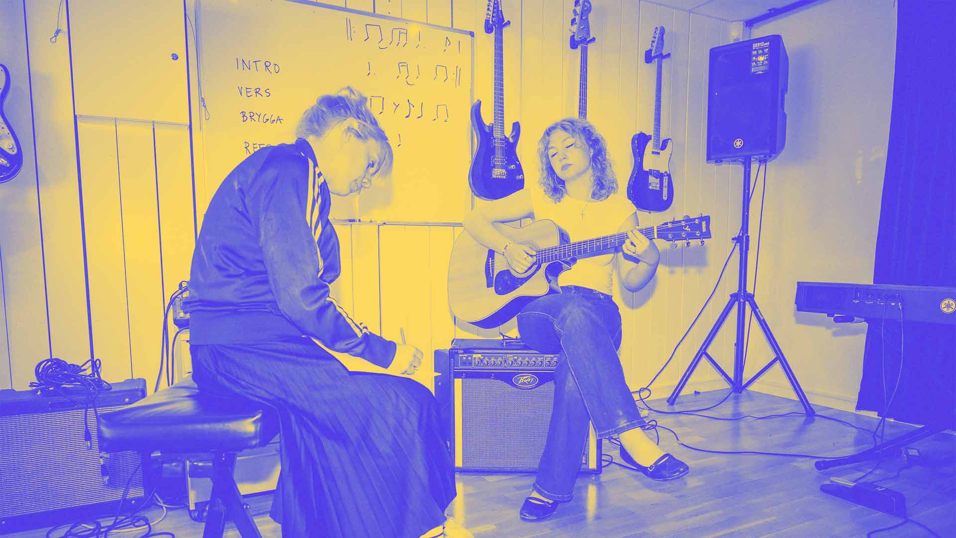 Elev sjunger och spelar gitarr med lärare