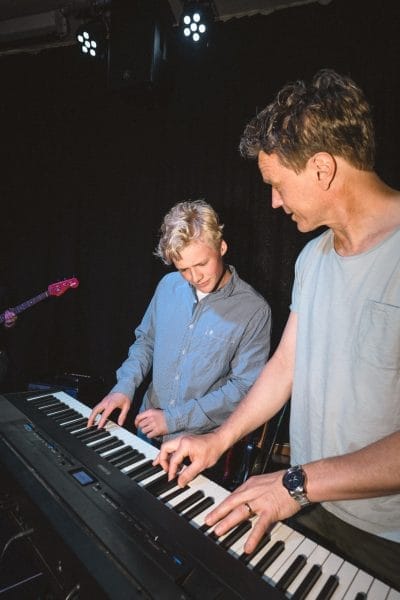 Lärare och elev spelar keyboard ihop.