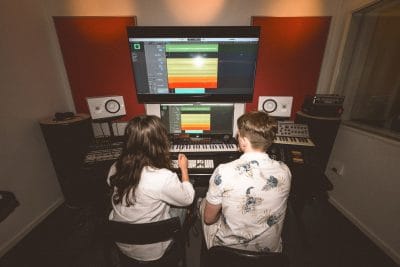 Två elever producerar musik i studion.