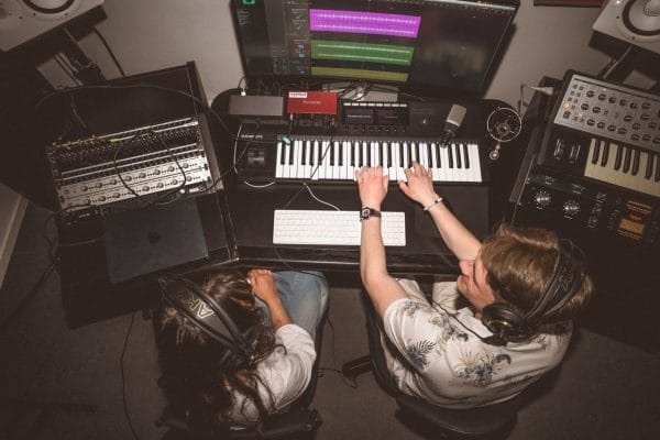 Två elever producerar musik ihop i musikstudion.
