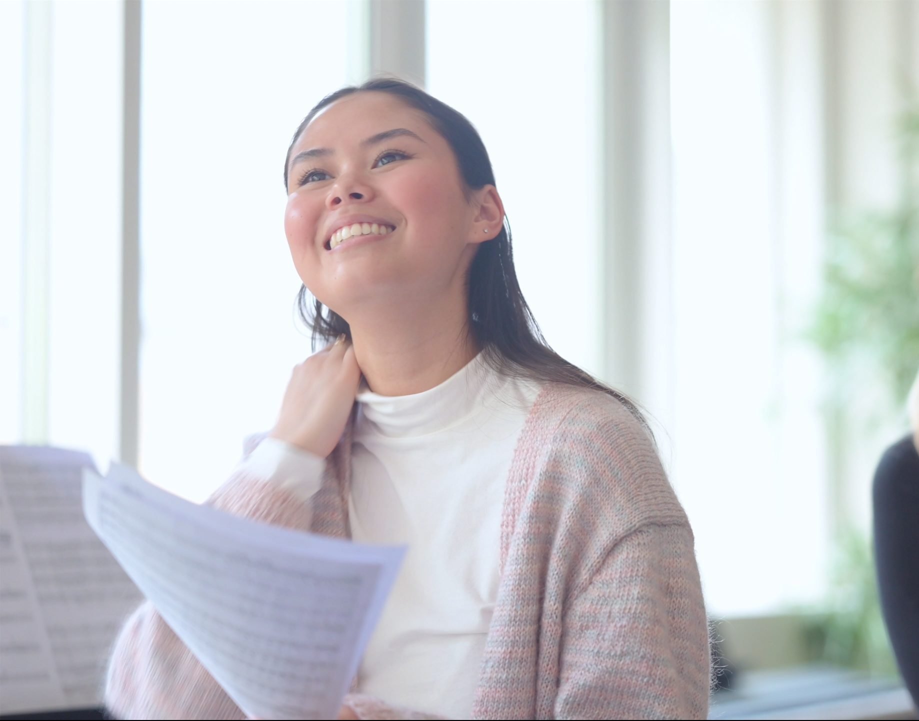 Elev sitter med papper i handen.