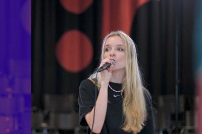 elev som sjunger på scen.