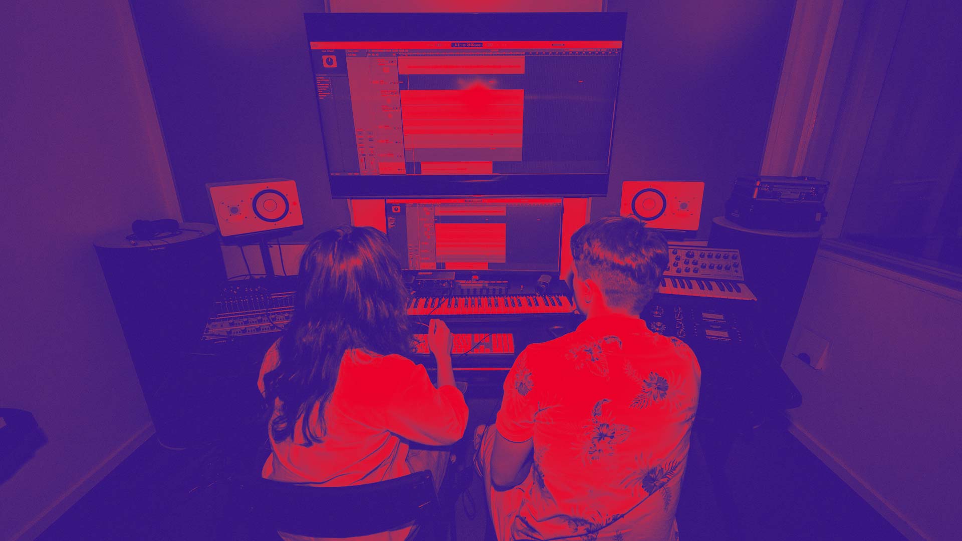 Två elever arbetar med musikproduktion i en inspelningsstudio.